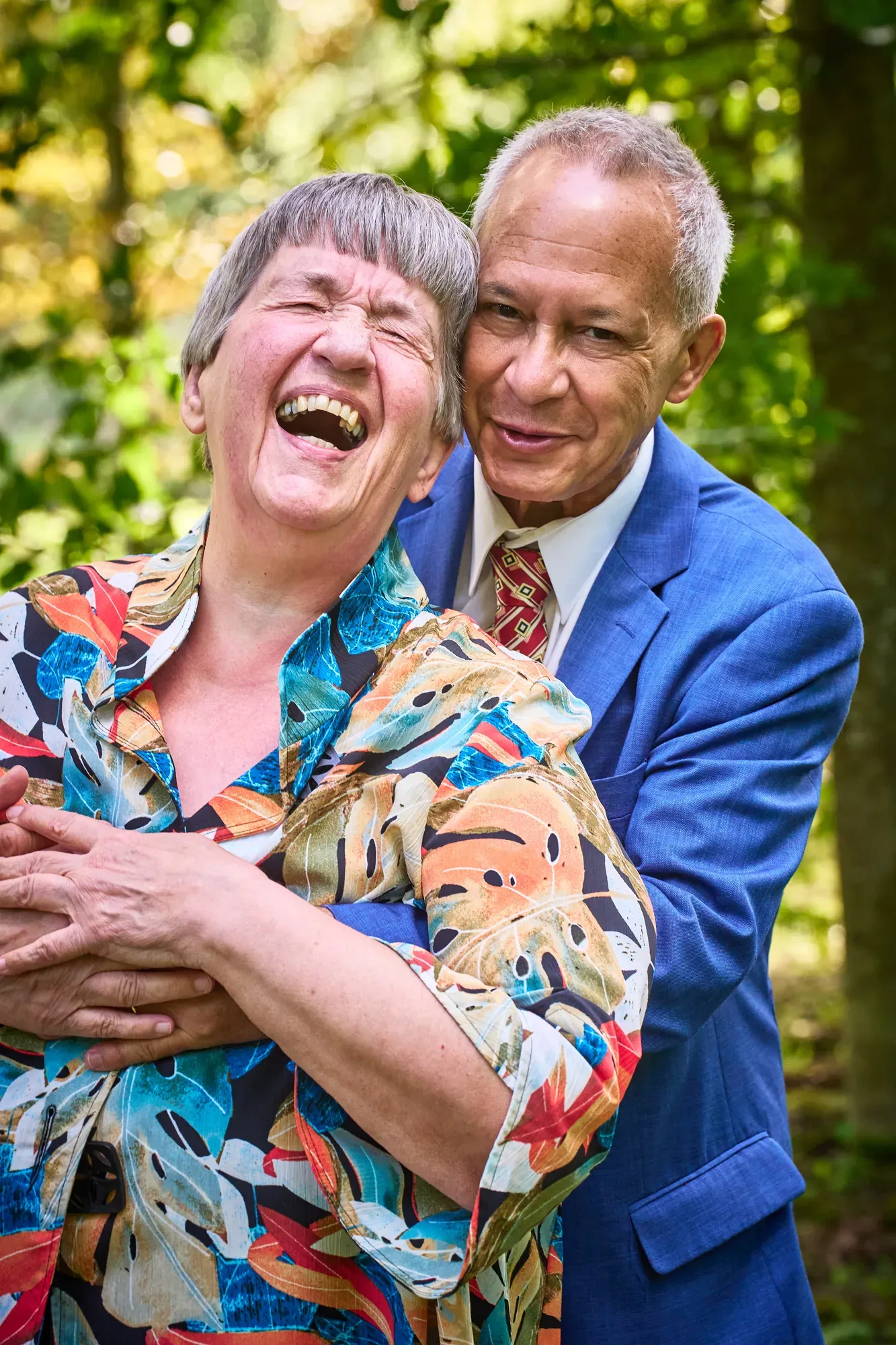 Opa en oma lachen hard terwijl ze elkaar omarmen