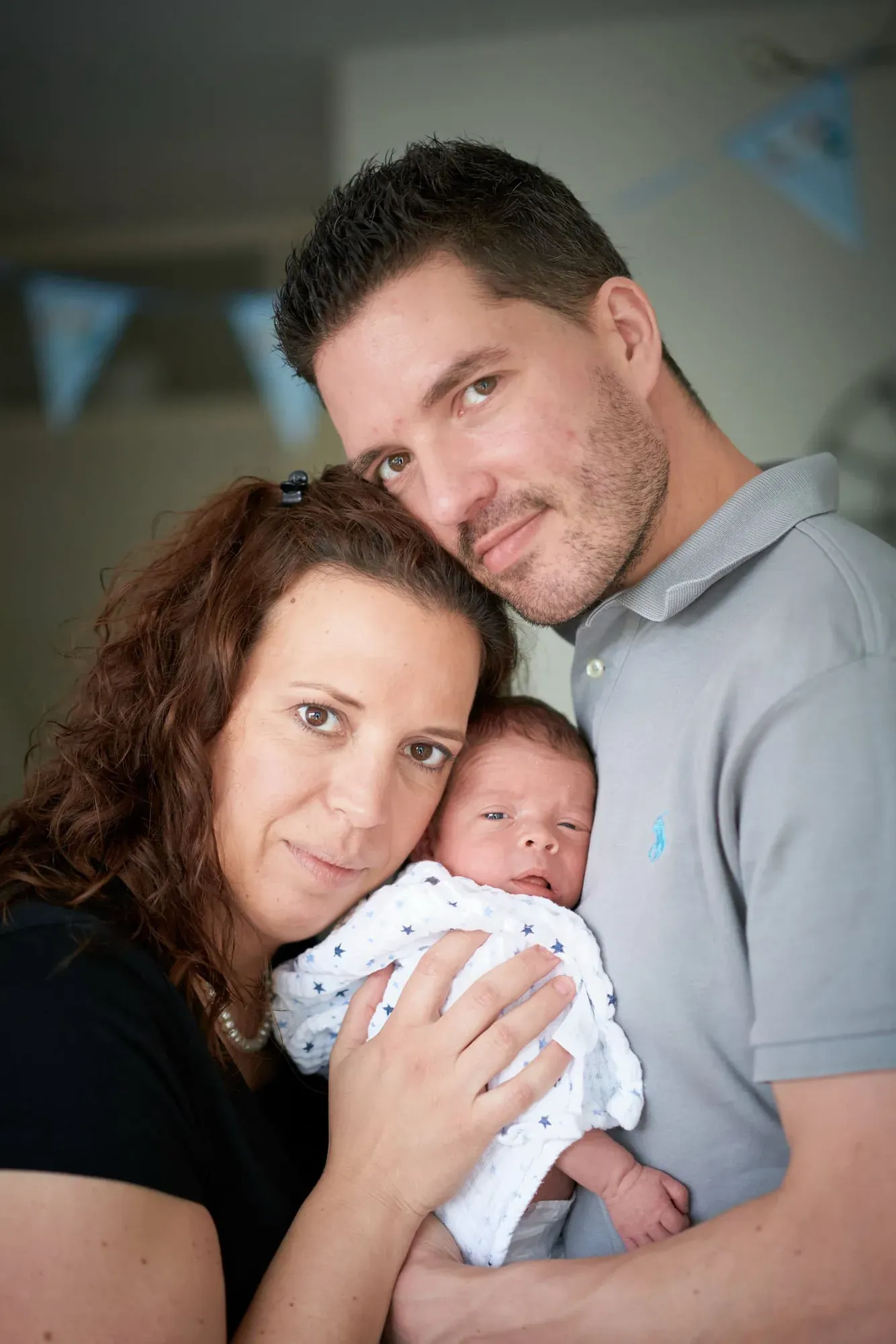Ouders houden hun baby samen vast en lachen