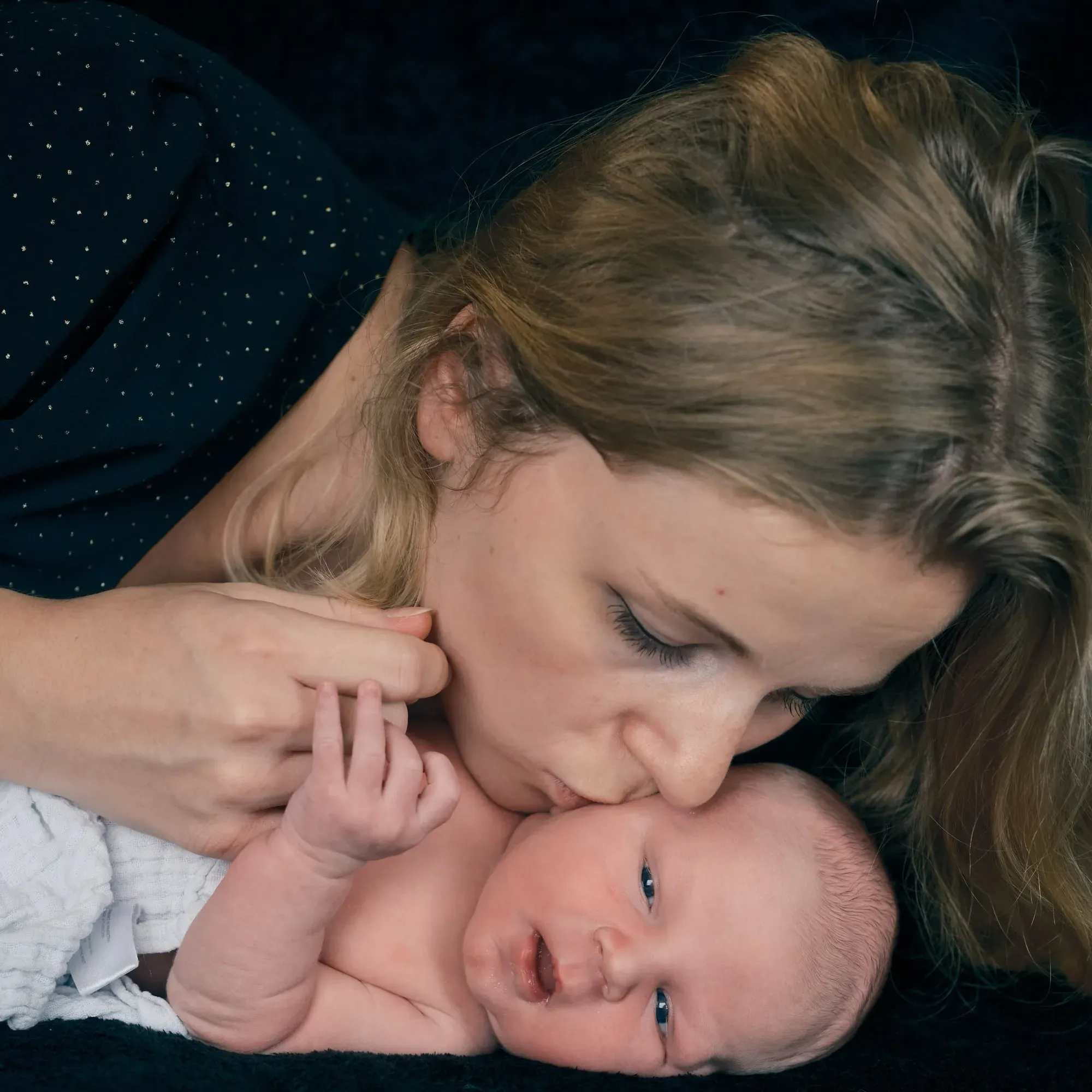 Moeder geeft haar baby een kusje op het hoofd