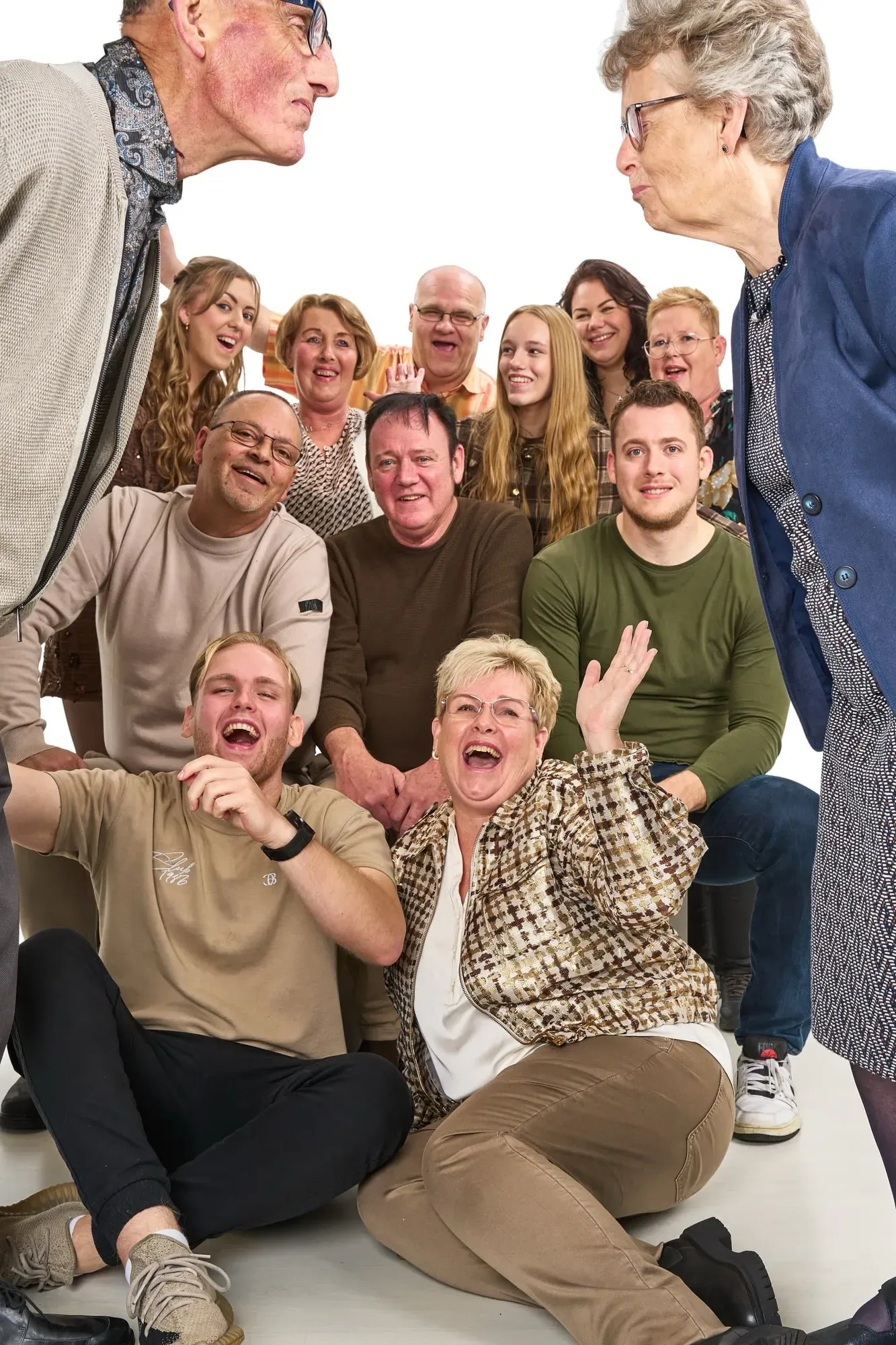 Grote groep staat en zit lachend dicht op elkaar in de studio