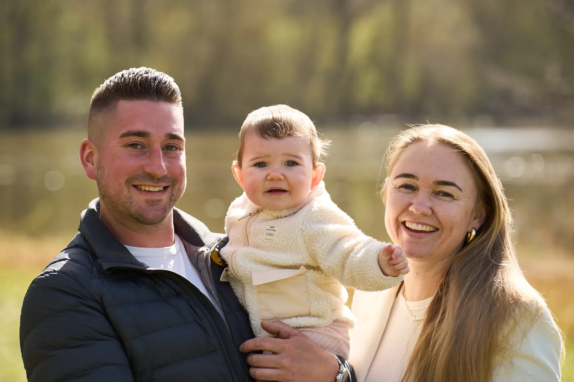 Ouders met hun baby in zacht tegenlicht aan het water in het Westerpark