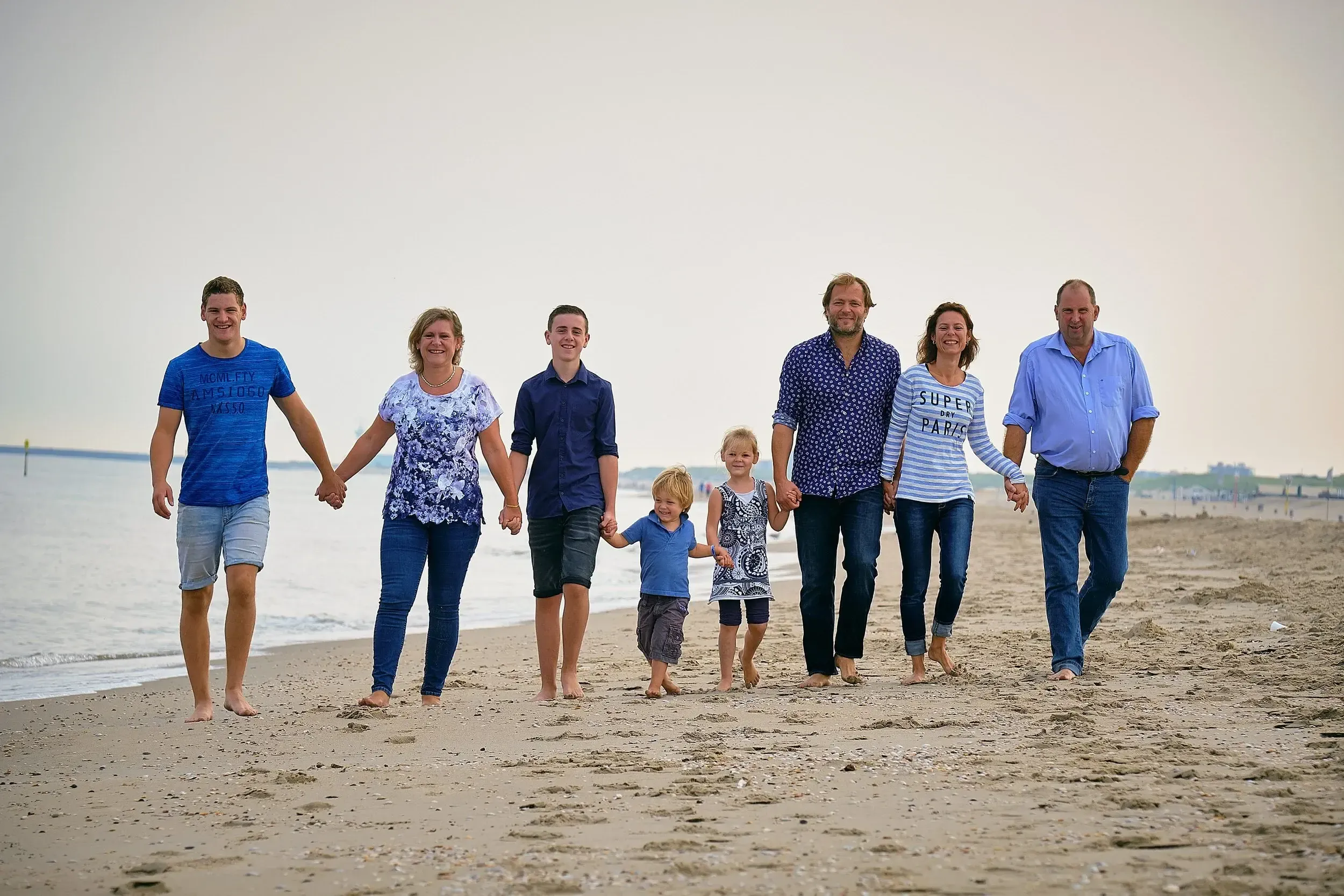 Een familieshoot op het strand in de ochtend geeft op een mooie dag mooi zacht licht