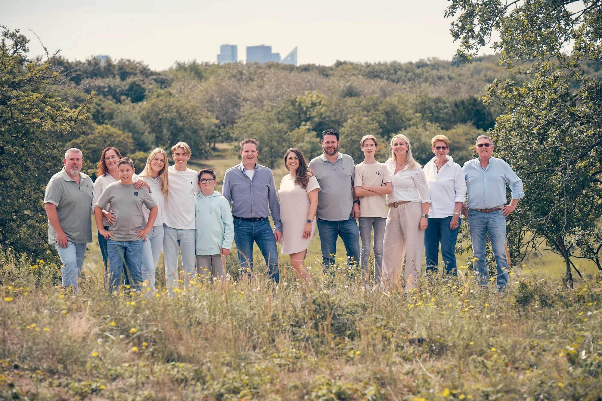 Grote familie staat in het helmgras in de vallei, met in de verte de torens van de stad