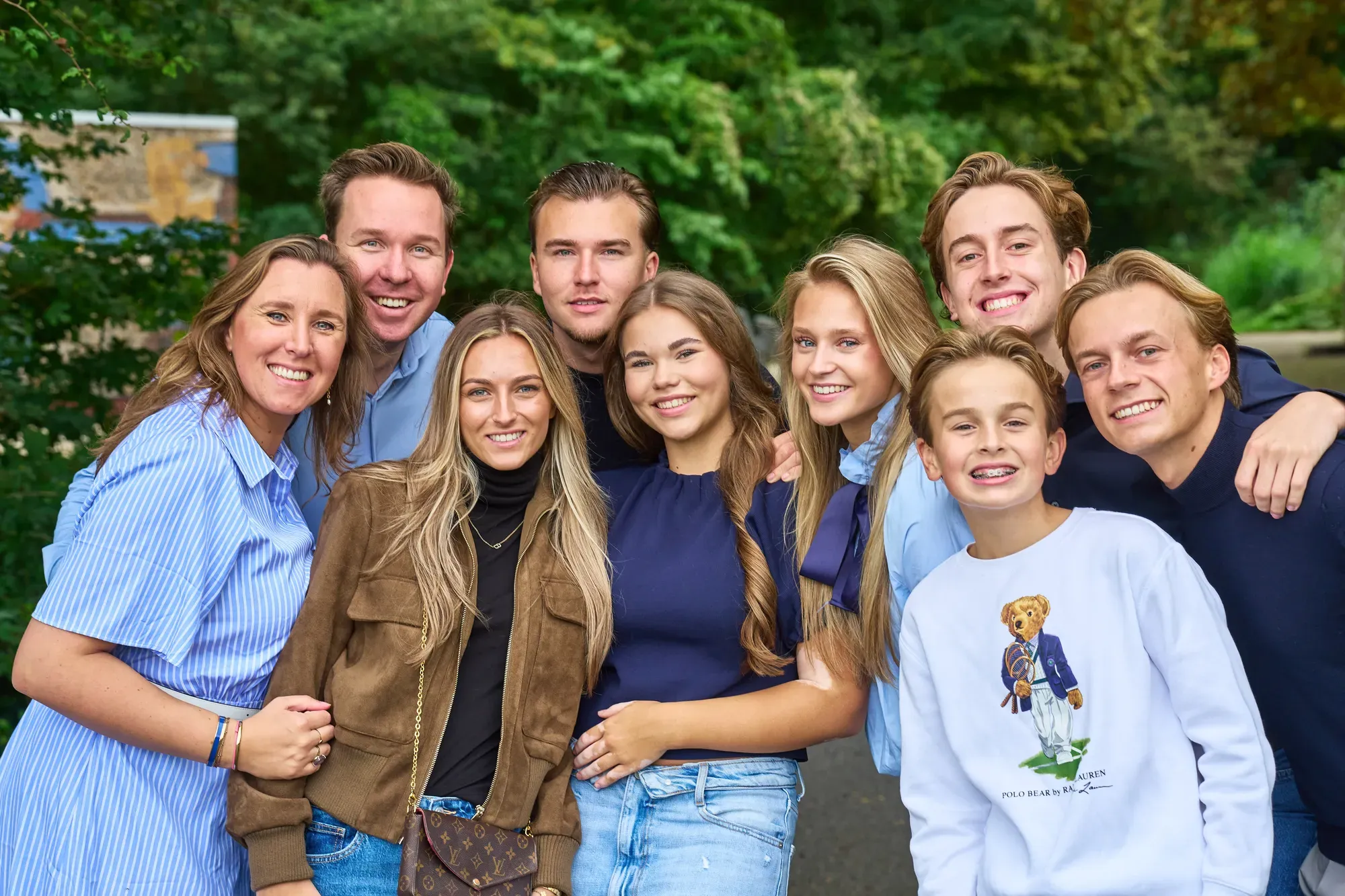 Kleinkinderen staan dicht tegen elkaar aan en lachen naar de camera