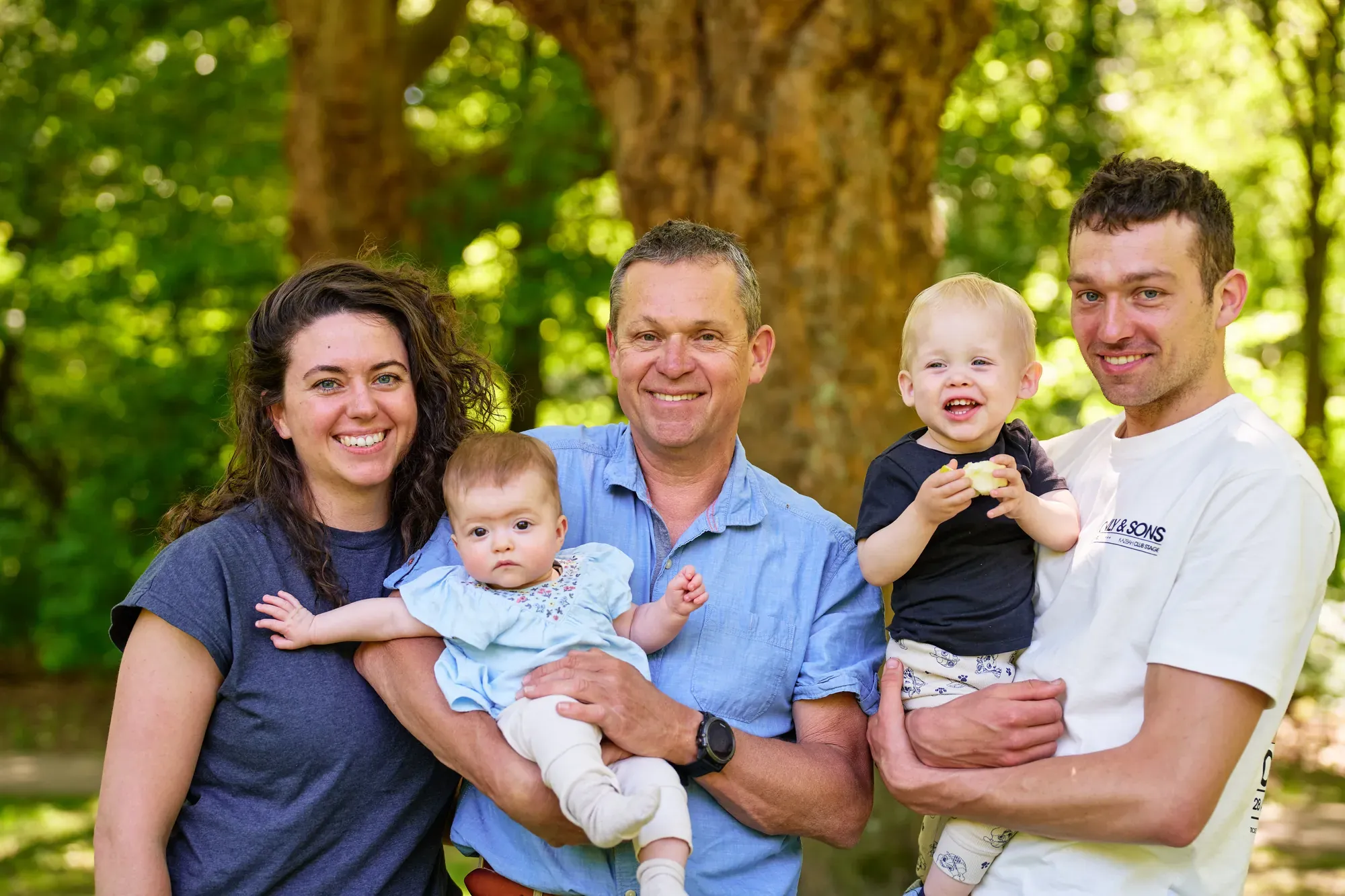 Familie met twee kleine kinderen in open schaduw onder een grote boom in het Westerpark