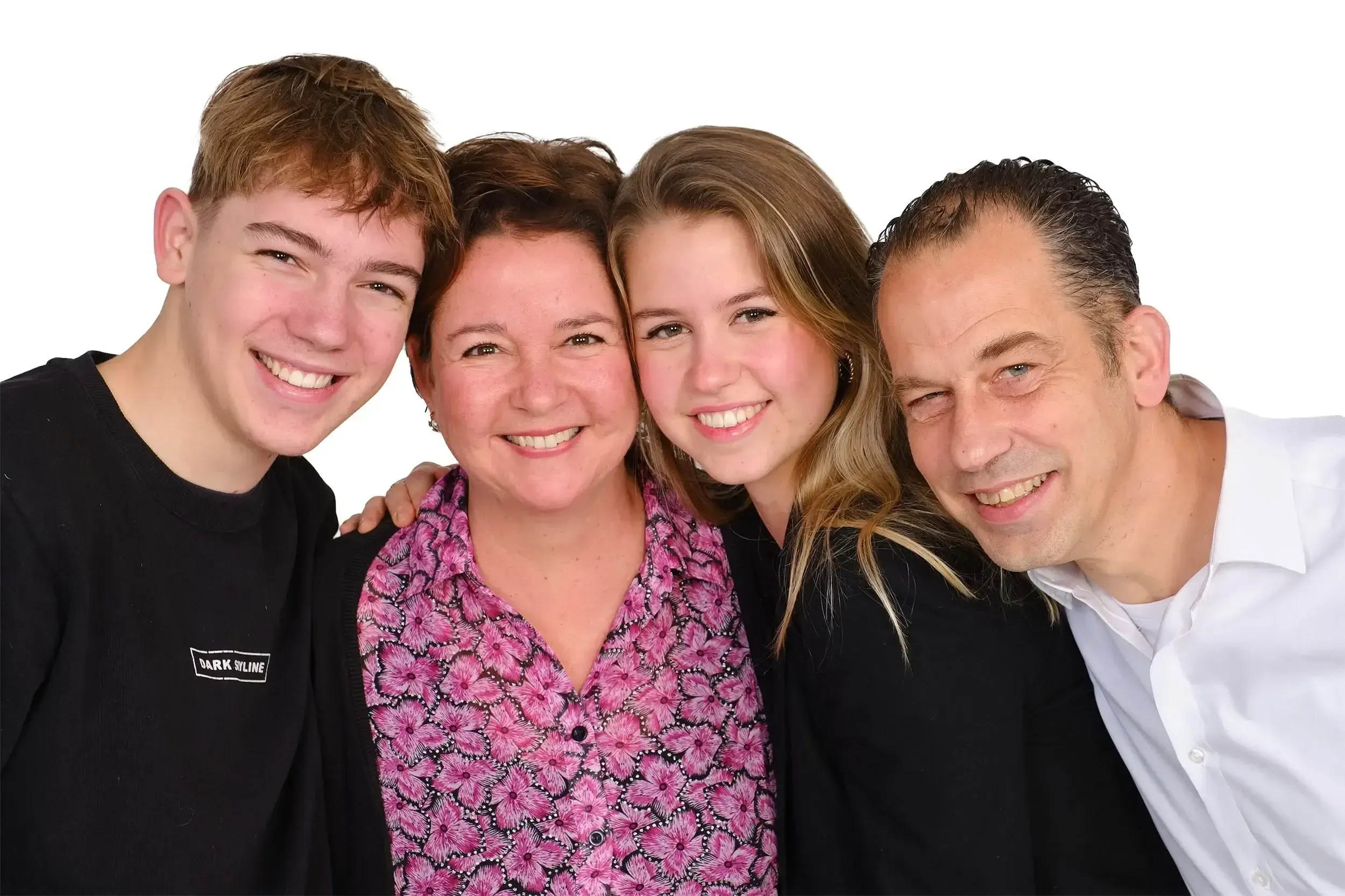 Foto van een gelukkige familie met vier mensen die dicht bij elkaar staan, lachend, tegen een witte achtergrond.