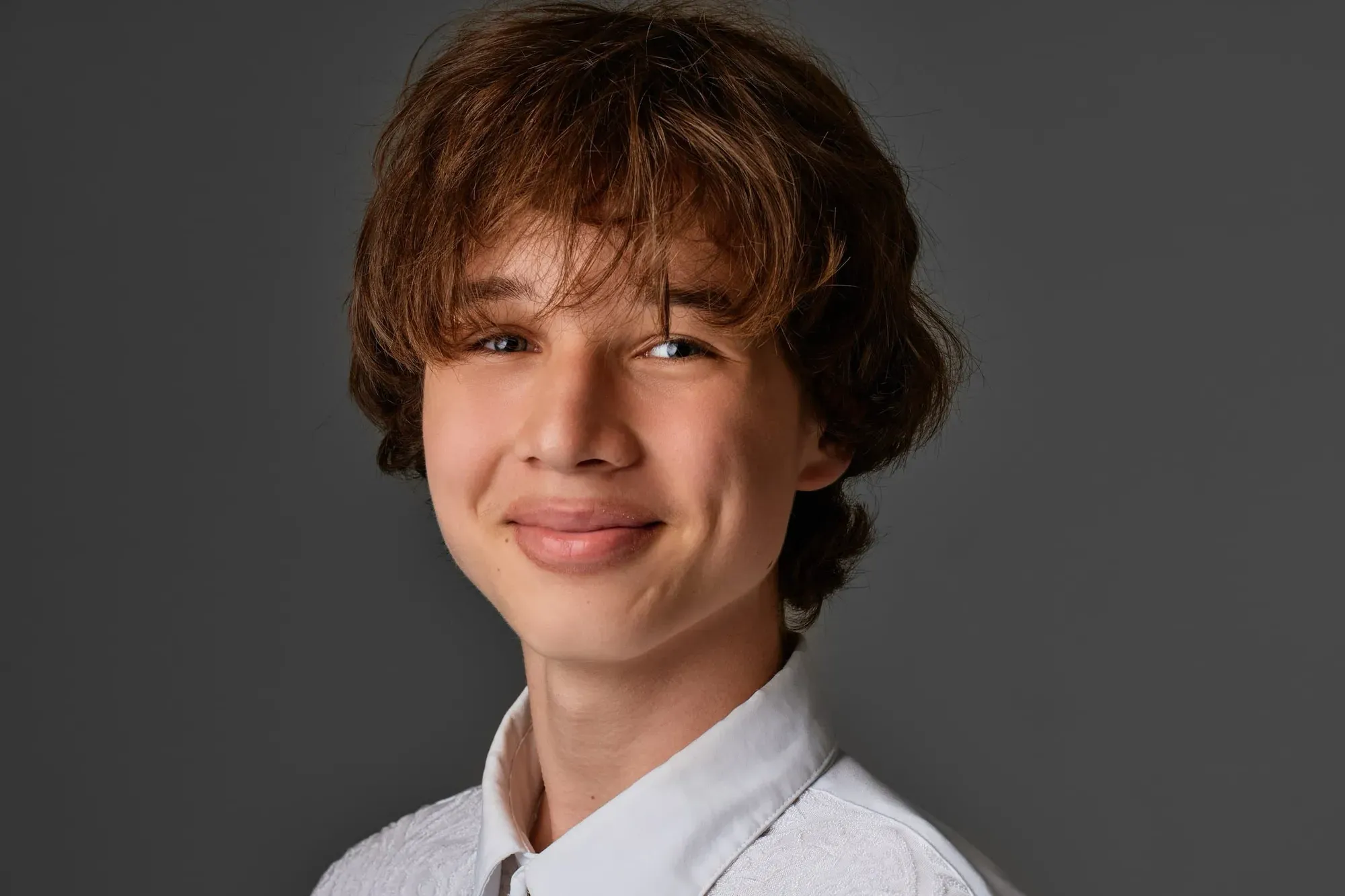 Portret van een jongen voor een grijze achtergrond