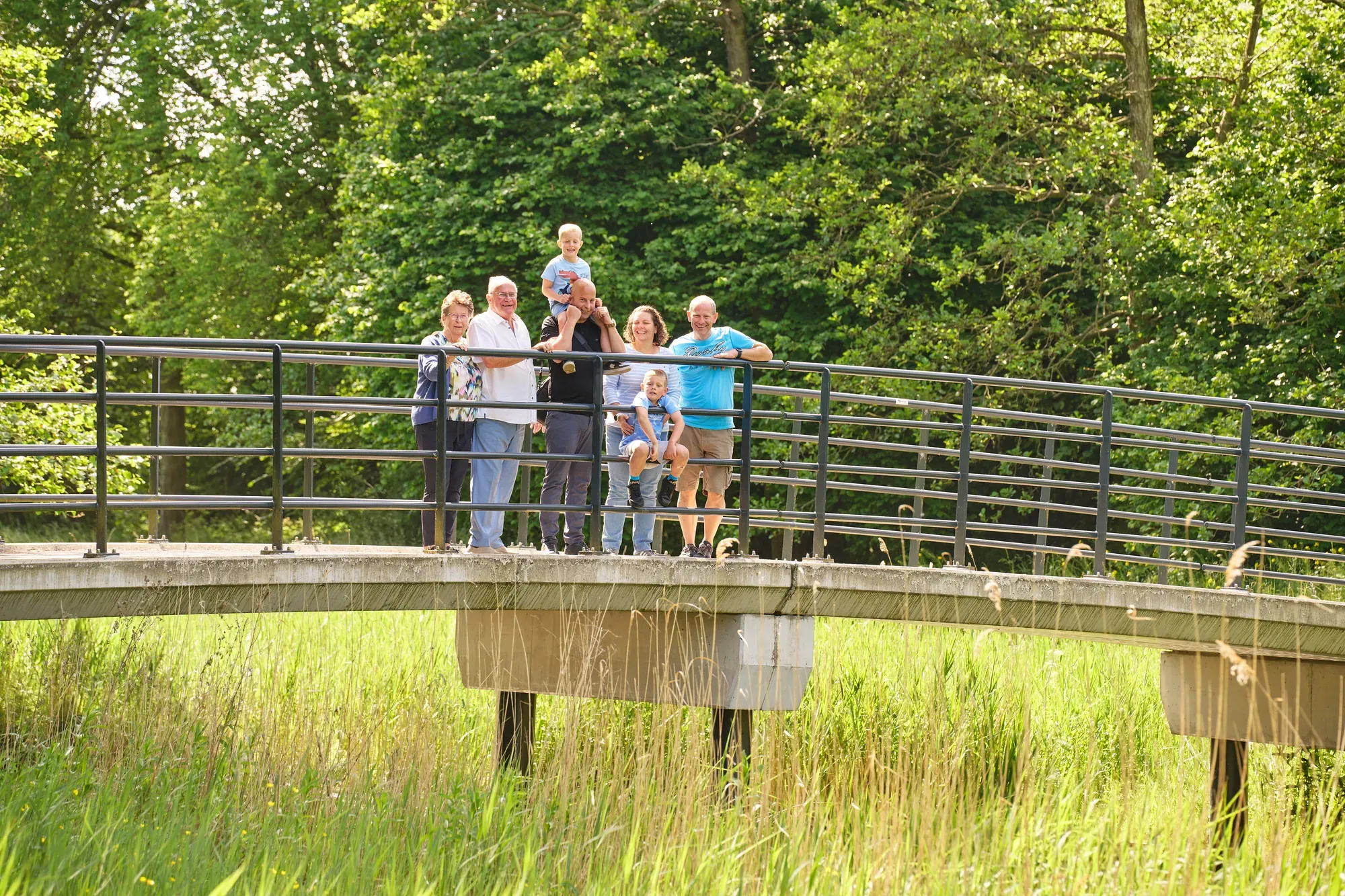 Familie staat op een houten bruggetje in het Westerpark