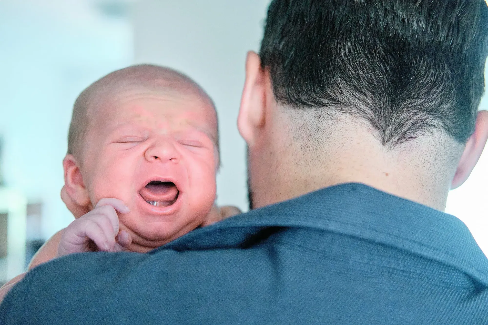Baby huilt op de schouder van papa