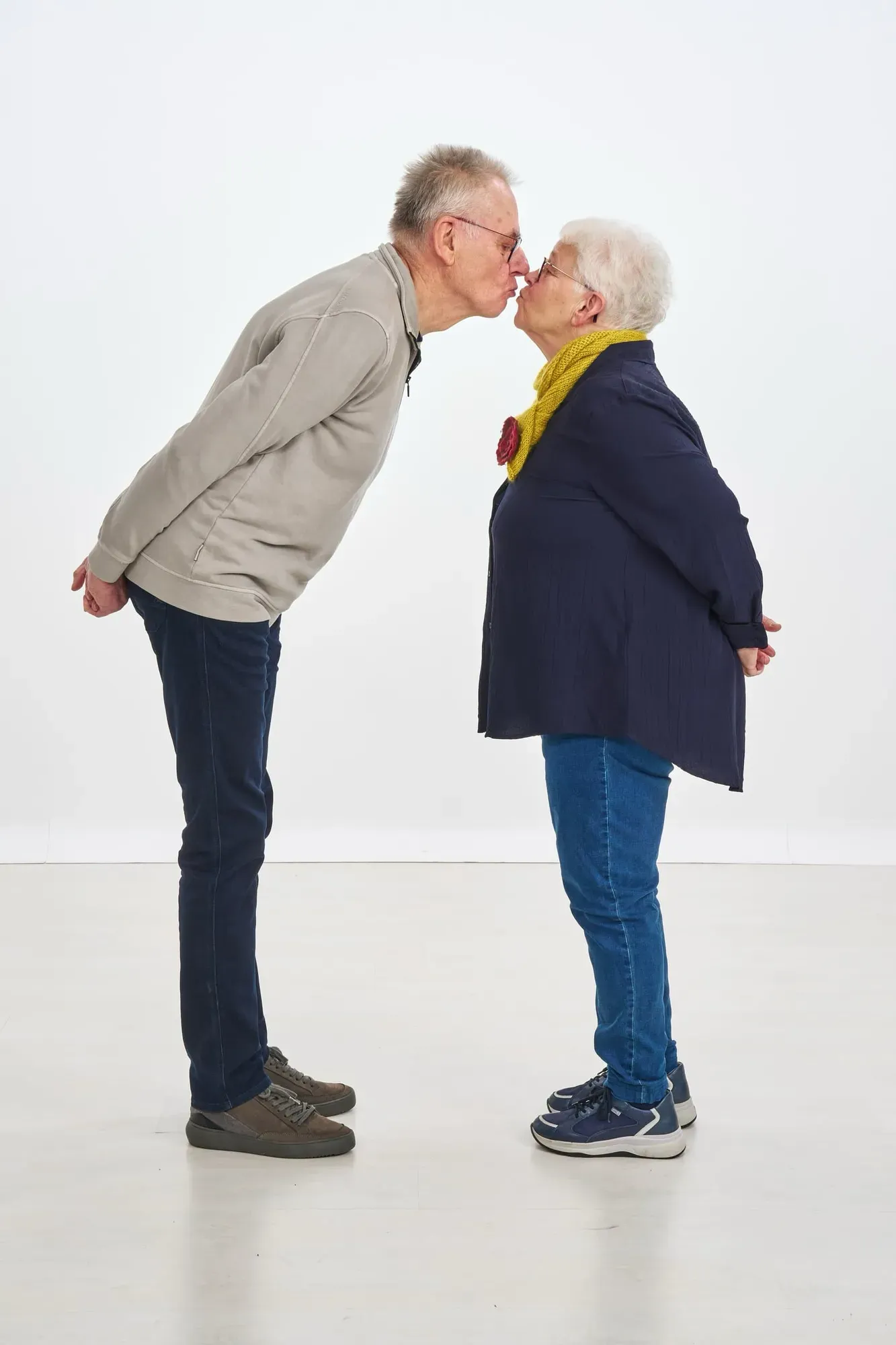 Opa en oma geven elkaar een kus in de witte studio