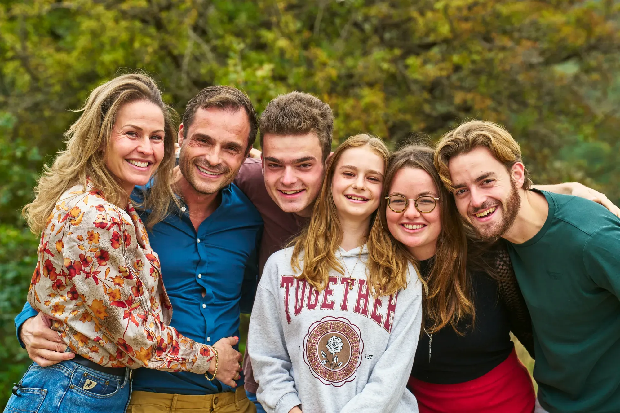 Familieportret van dichtbij met een zachte, groene achtergrond