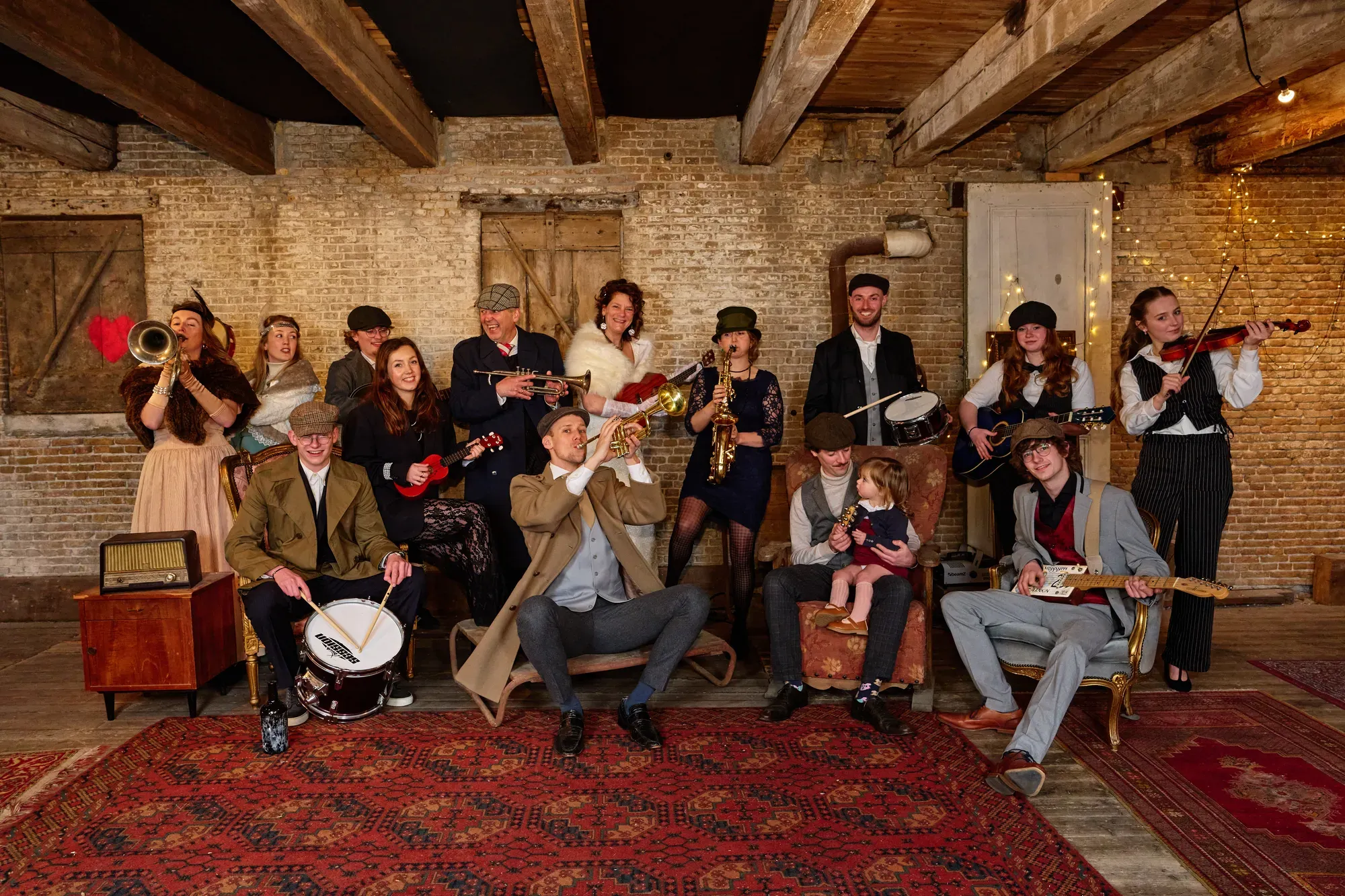 Grote familie in Peaky Blinders-kleding met gitaren en blaasinstrumenten, deels zittend en deels staand