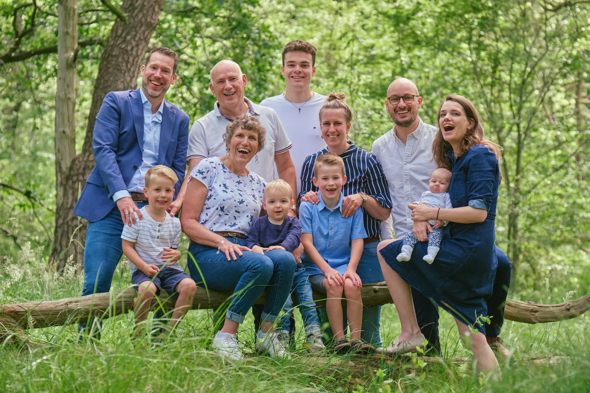 Familie zit samen op een omgevallen boomstam in het bos