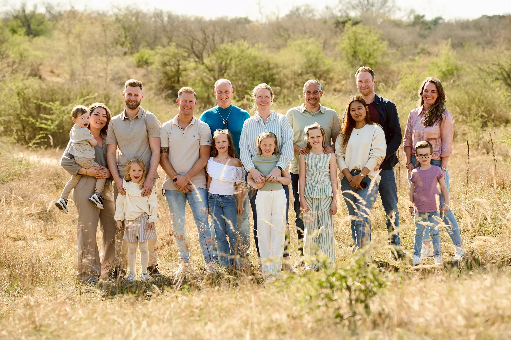 Grote familie van drie generaties staat samen in het helmgras