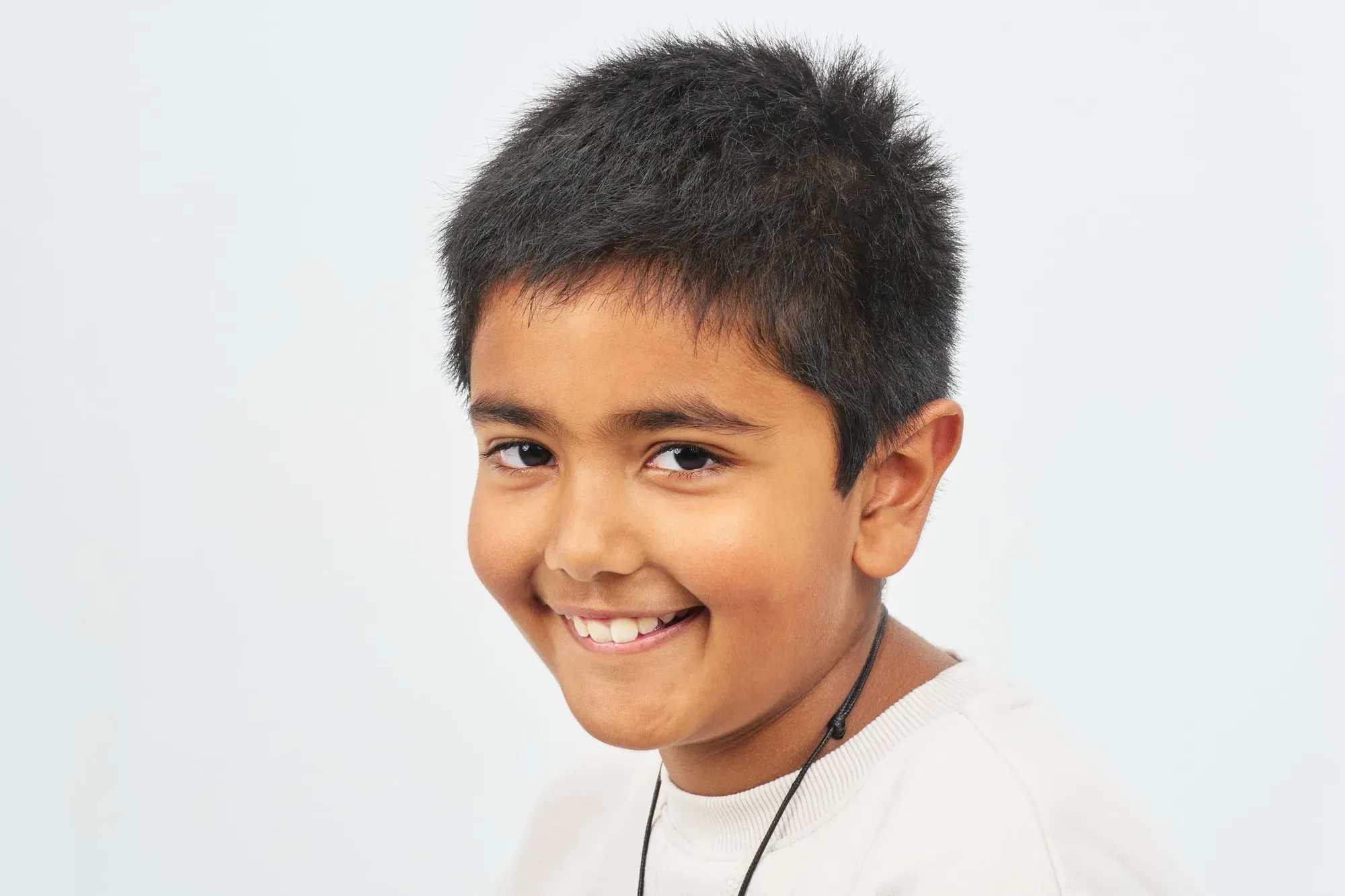 Portret van een lachende jongen voor een witte achtergrond
