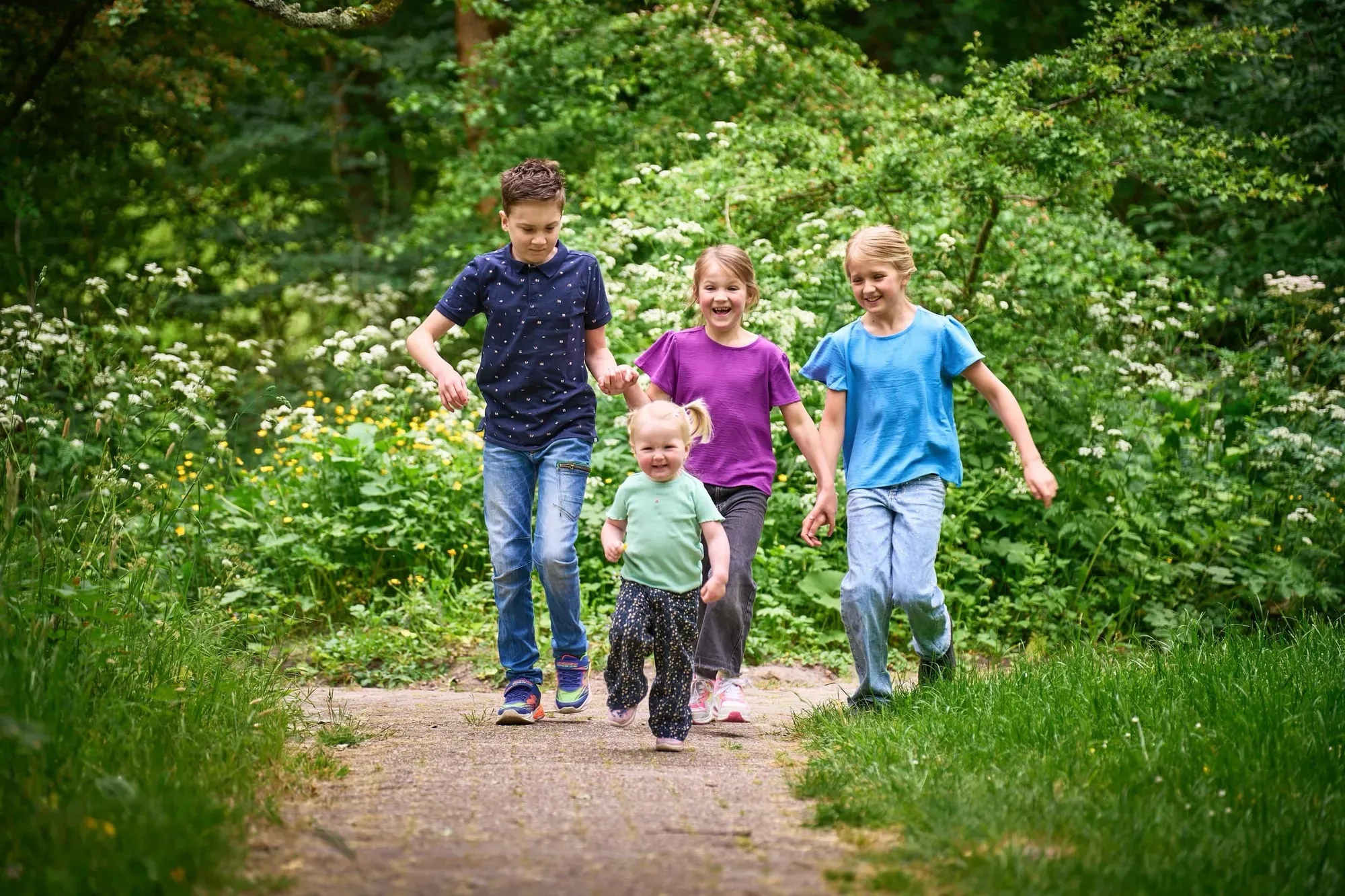 Kinderen lopen samen over een bospad