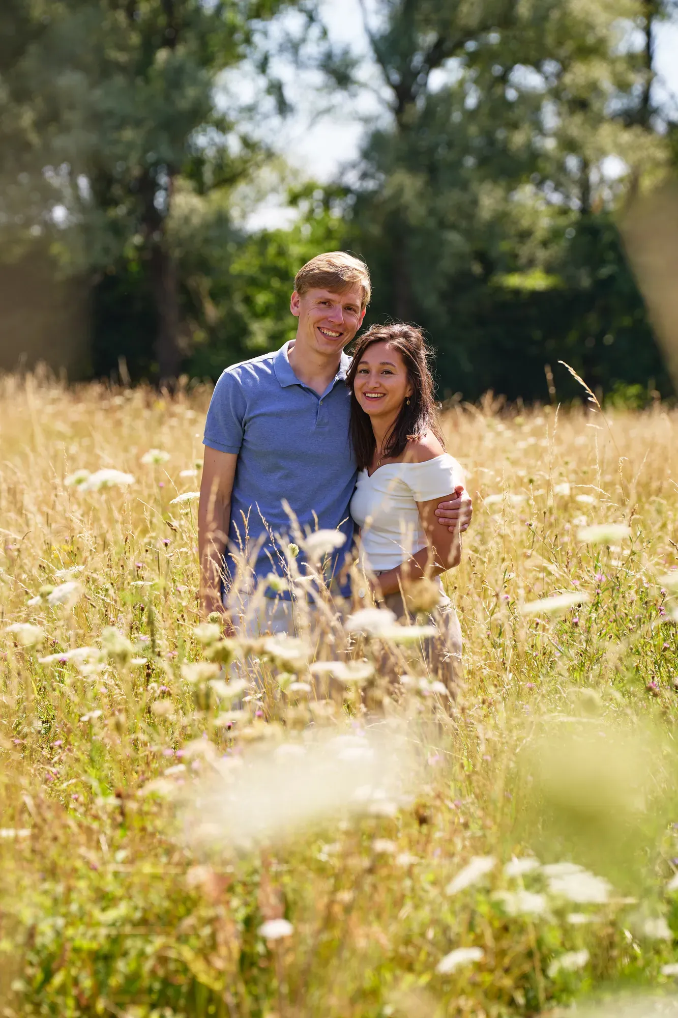Stel staat dicht tegen elkaar aan tussen de zomerbloemen in het Westerpark