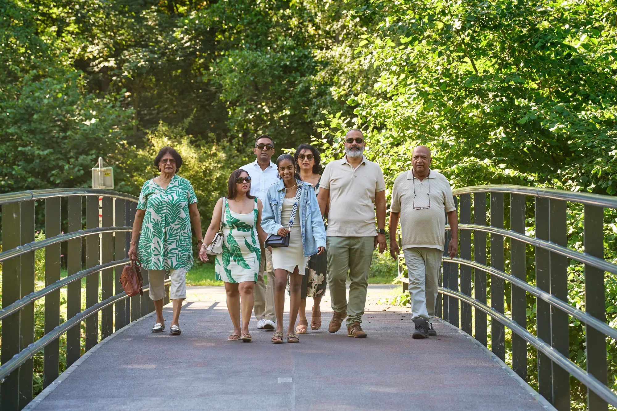 Grote familie loopt over een bruggetje in het Westerpark