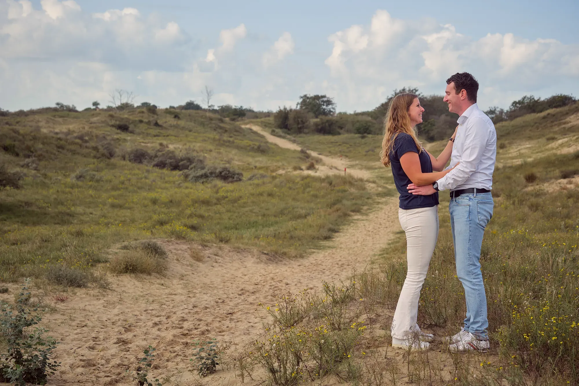 Stel staat samen in de vallei met de duinen om zich heen, eind september