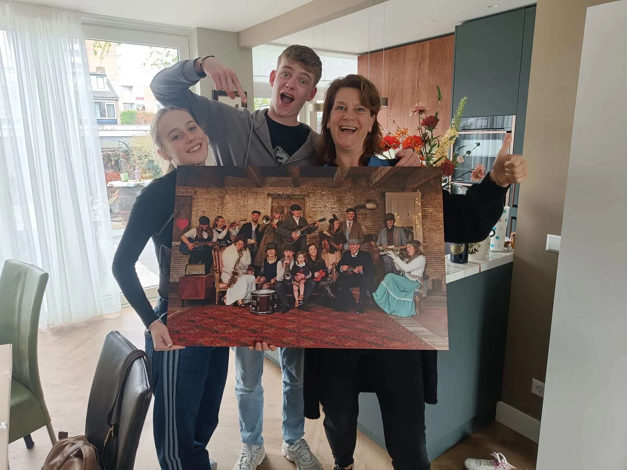 De afgedrukte groepsfoto hangt aan de muur bij de familie thuis