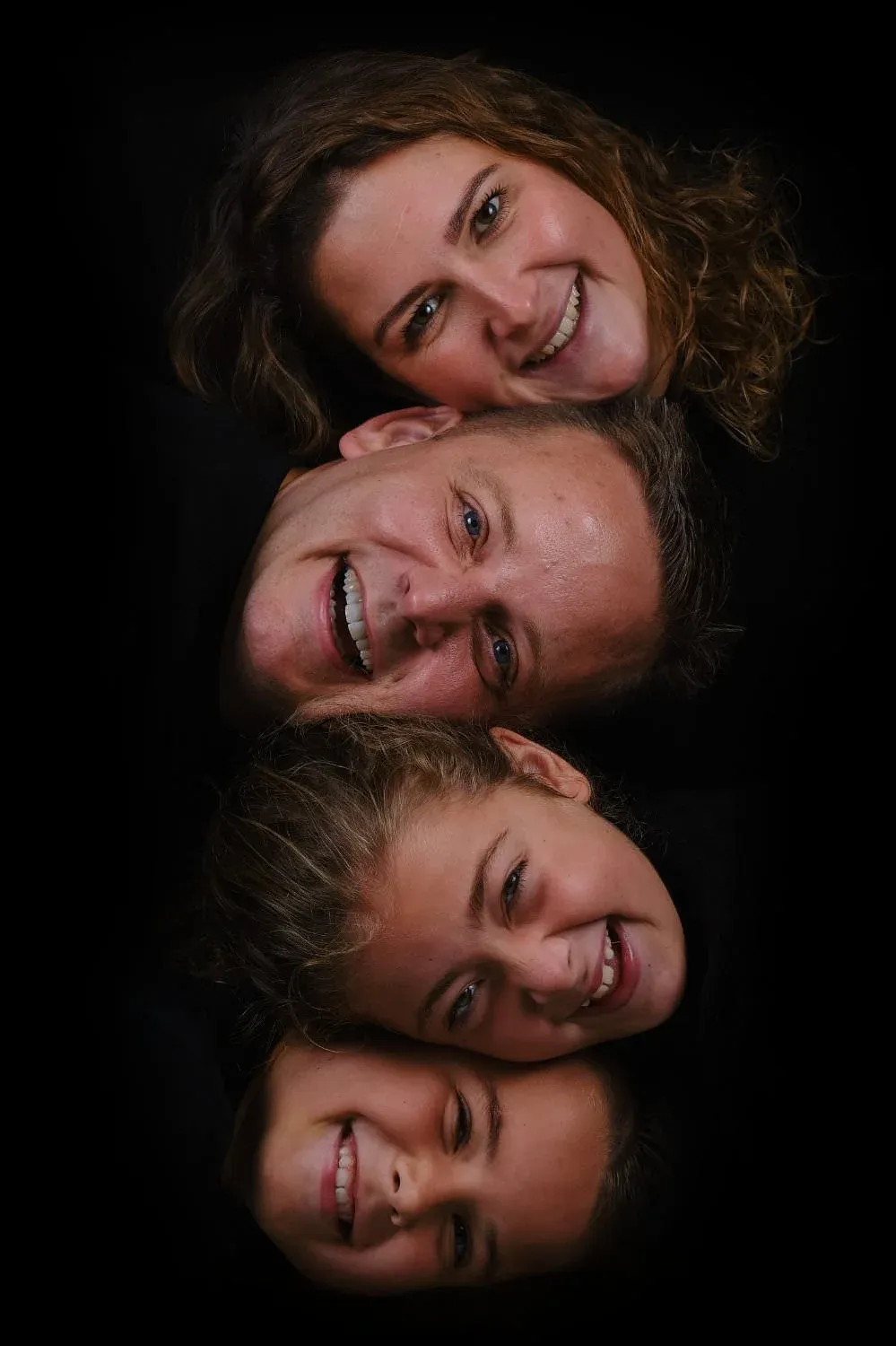 Close-up van een gezin met vier gezichten dicht bij elkaar tijdens een familieshoot in de fotostudio