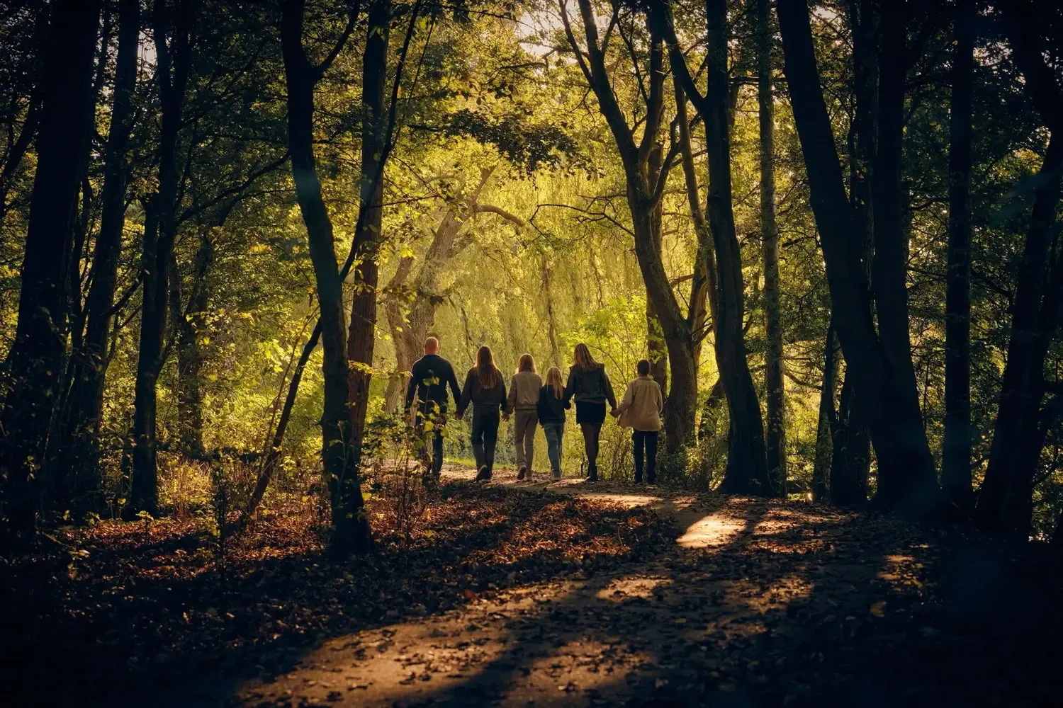 Kind dat op het strand loopt, met de focus op de benen en de witte jurk en de schaduw op het zand.